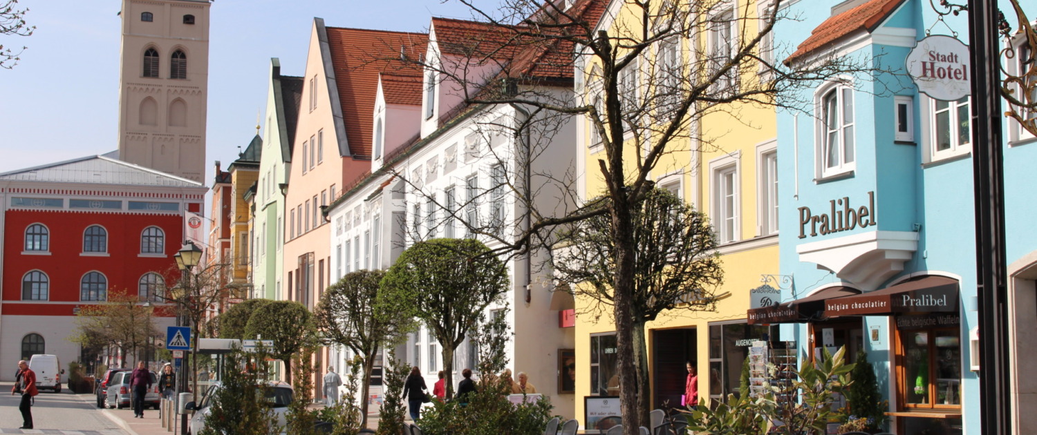 Bunte Fassaden und Straßencafés in der Erdinger Innenstadt bei sonnigem Wetter.