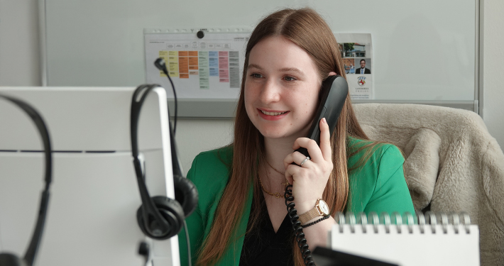 Patricia Schneider am Schreibtisch im Büro. Sie telefoniert.